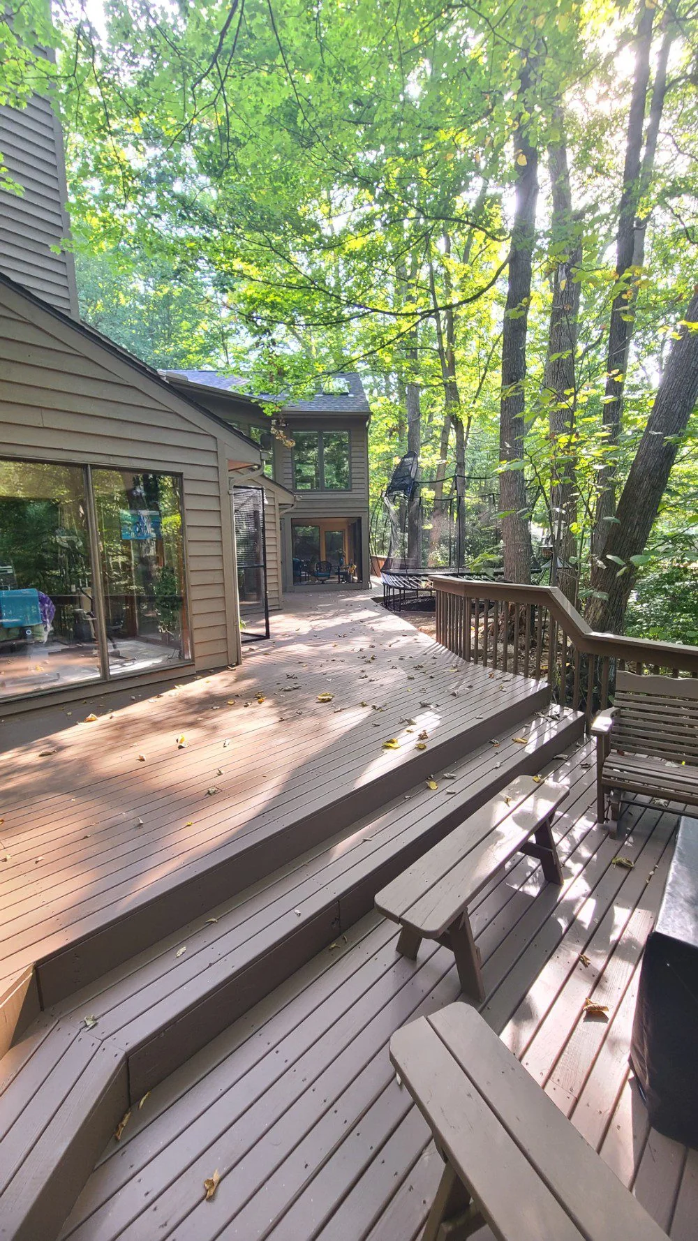 Large wood deck wrapping around a wooded home