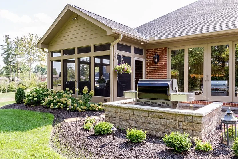 Covered outdoor room opening to a landscaped Cincinnati yard